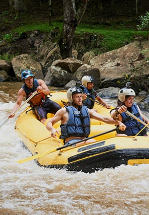 Tim wisatawan mengarungi arung jeram dengan perahu karet